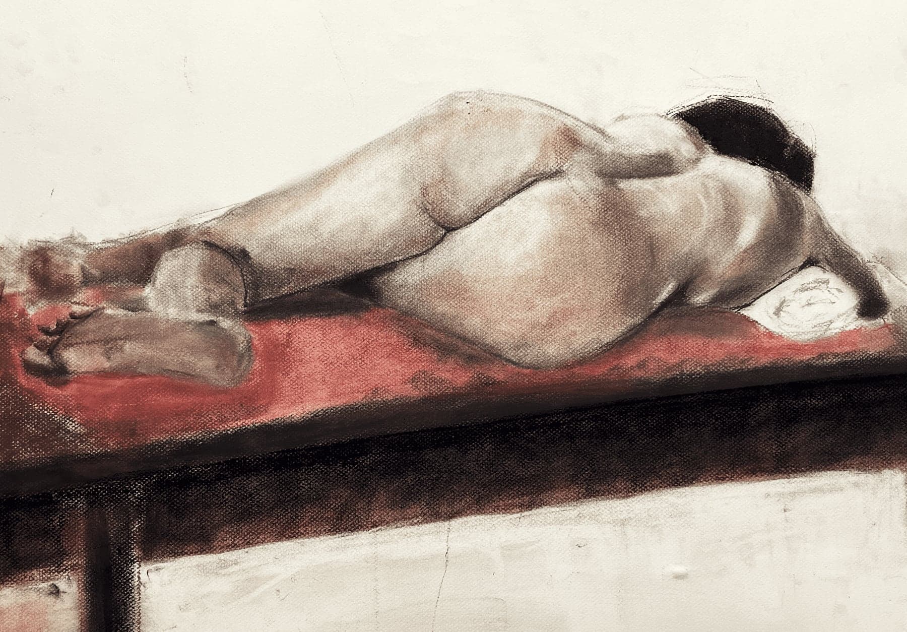 Horizontal pastel figure study of a reclining body on a red studio bench.