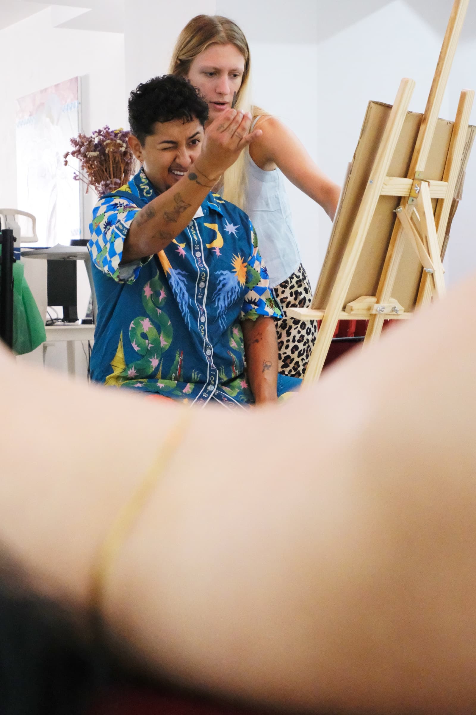 Participants gather around easels during a live drawing and painting session.